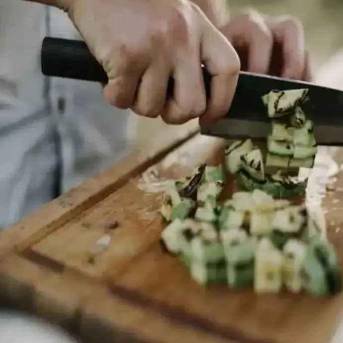 Chef competent with food hygiene chopping courgettes
