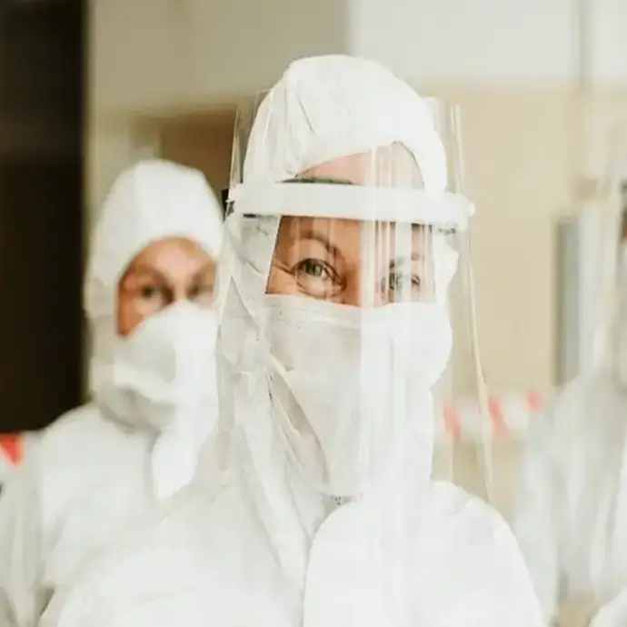 Staff in PPE and coveralls working with COSHH materials