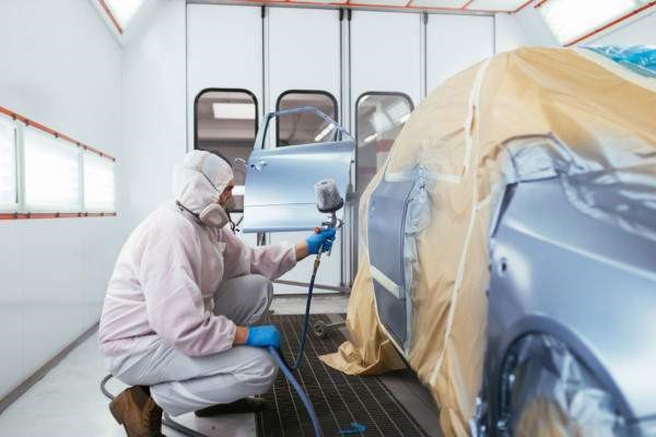 Man spraying car with PPE on