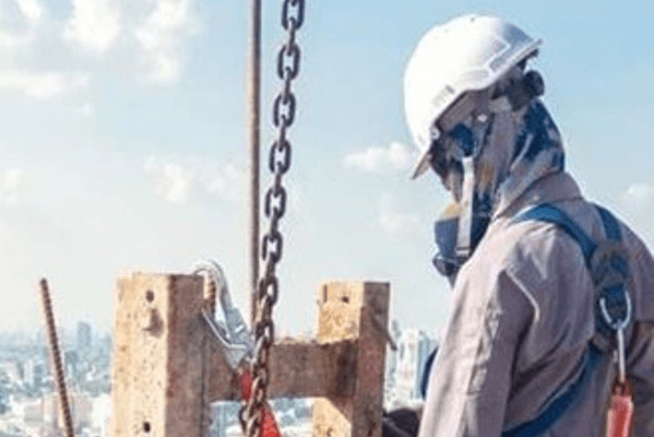 A construction worker on top of a tower block under construction